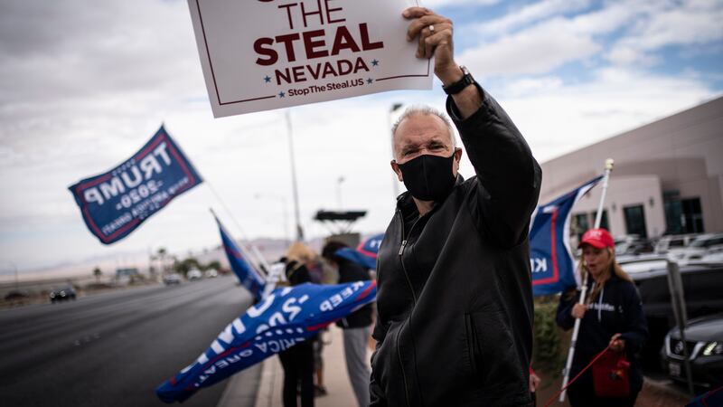 Supporters of President Donald Trump hold signs as they stand outside of the Clark County...