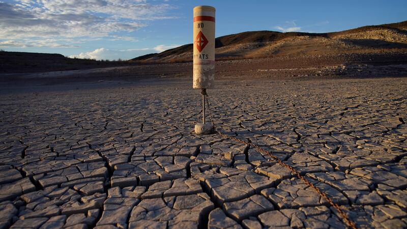 A buoy sits high and dry on cracked earth previously under the waters of Lake Mead at the Lake...
