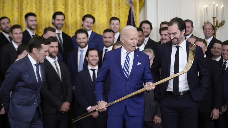 President Joe Biden looks over a hockey stick with team captain Mark Stone, during an event to...