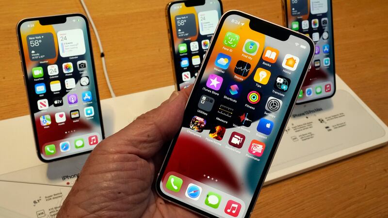 FILE - The line-up of the Apple iPhone 13 is displayed on their first day of sale, in New...
