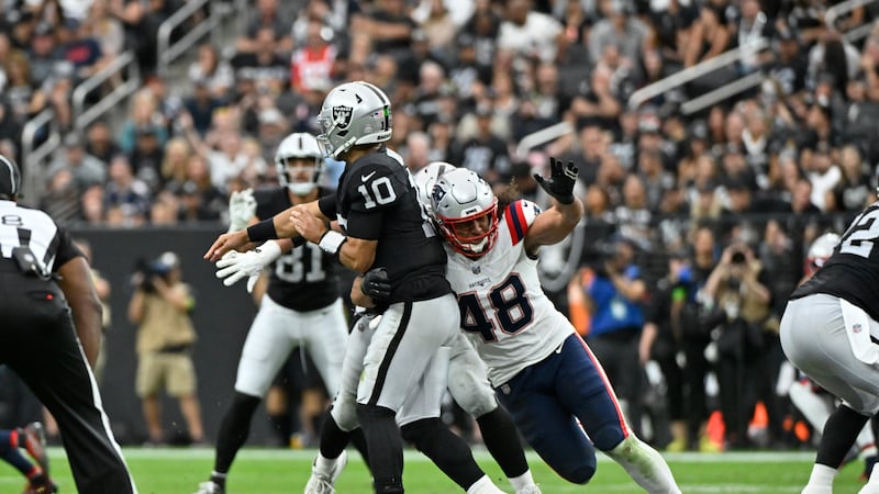 Las Vegas Raiders quarterback Jimmy Garoppolo is hit by New England Patriots linebacker...