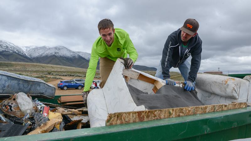 Daniel Gray, left, and Anthony Sawyer stuff the dumpster during the Keep Truckee Meadows...