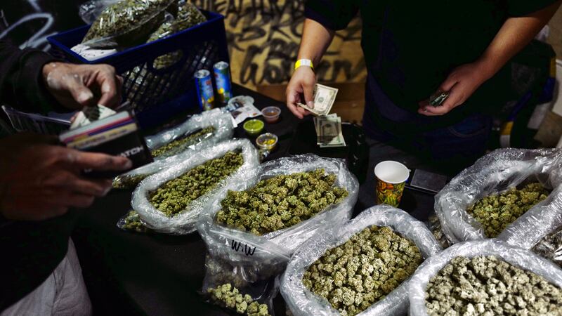 In this April 15, 2019, file photo, a vendor makes change for a marijuana customer at a...