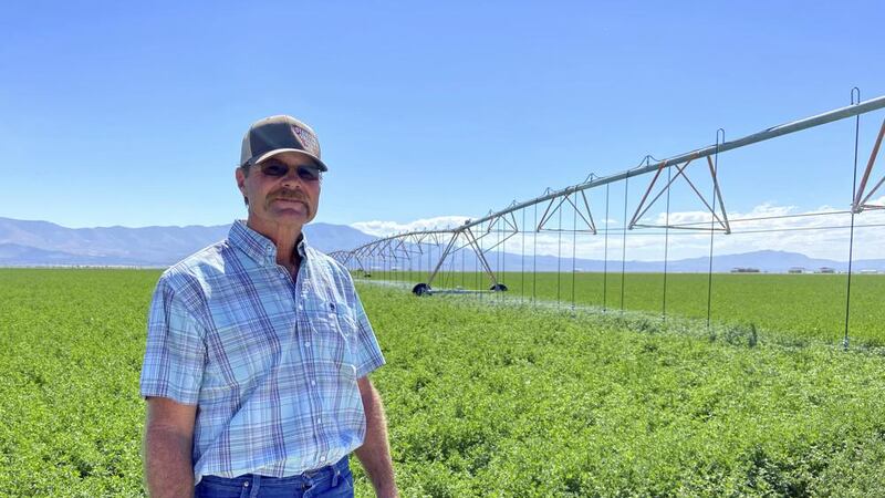 Marty Plaskett, a hay farmer in Diamond Valley, Nev., stands near one of his irrigation pivots...