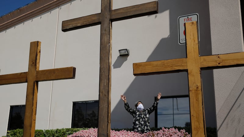 In this April 12, 2020, file photo, Norma Urrabazo prays while wearing a face mask before...