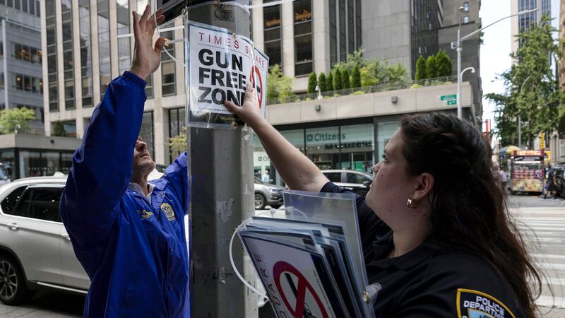 FILE — New York City Police Department Public Affairs officers set up signs reading 'Gun Free...