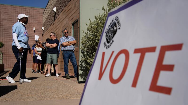 People wait in line to vote at a polling place on June 14, 2022, in Las Vegas. The Nevada...