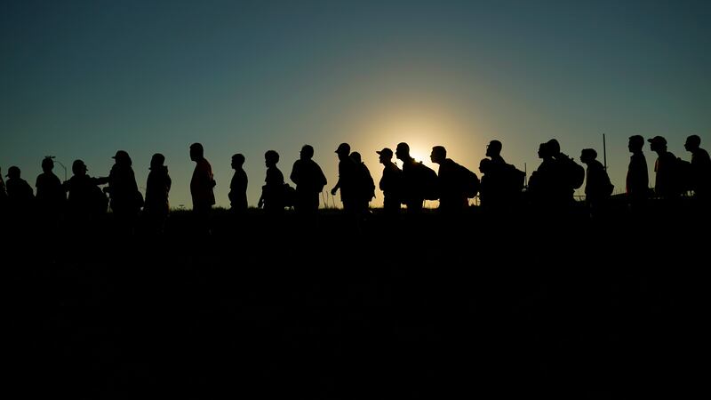Migrants who crossed the Rio Grande and entered the U.S. from Mexico are lined up for...