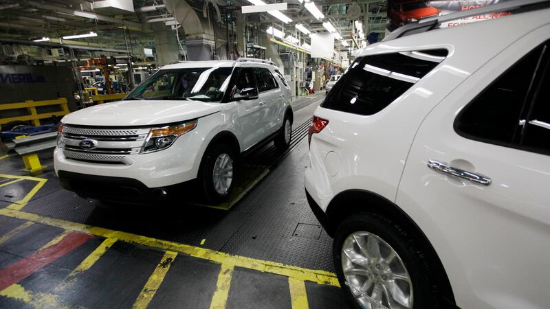 Plant employees drive 2011 Ford Explorer vehicles off the assembly line at Ford's Chicago...